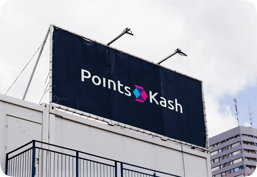 A rooftop billboard showing the PointsKash logo against a cloudy sky