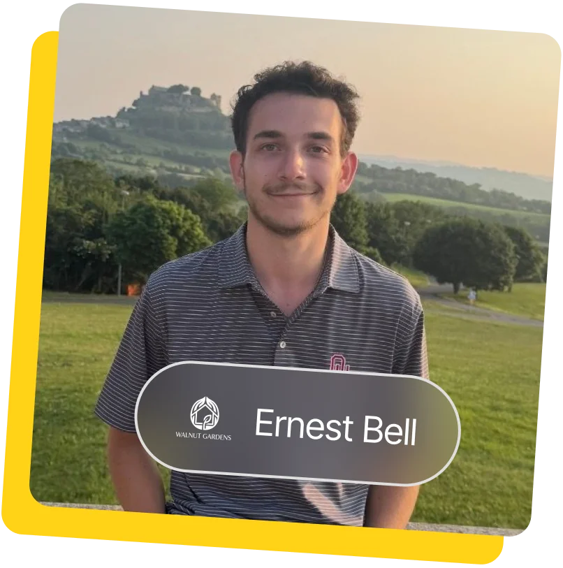 Ernest Bell smiling outdoors in a striped polo shirt