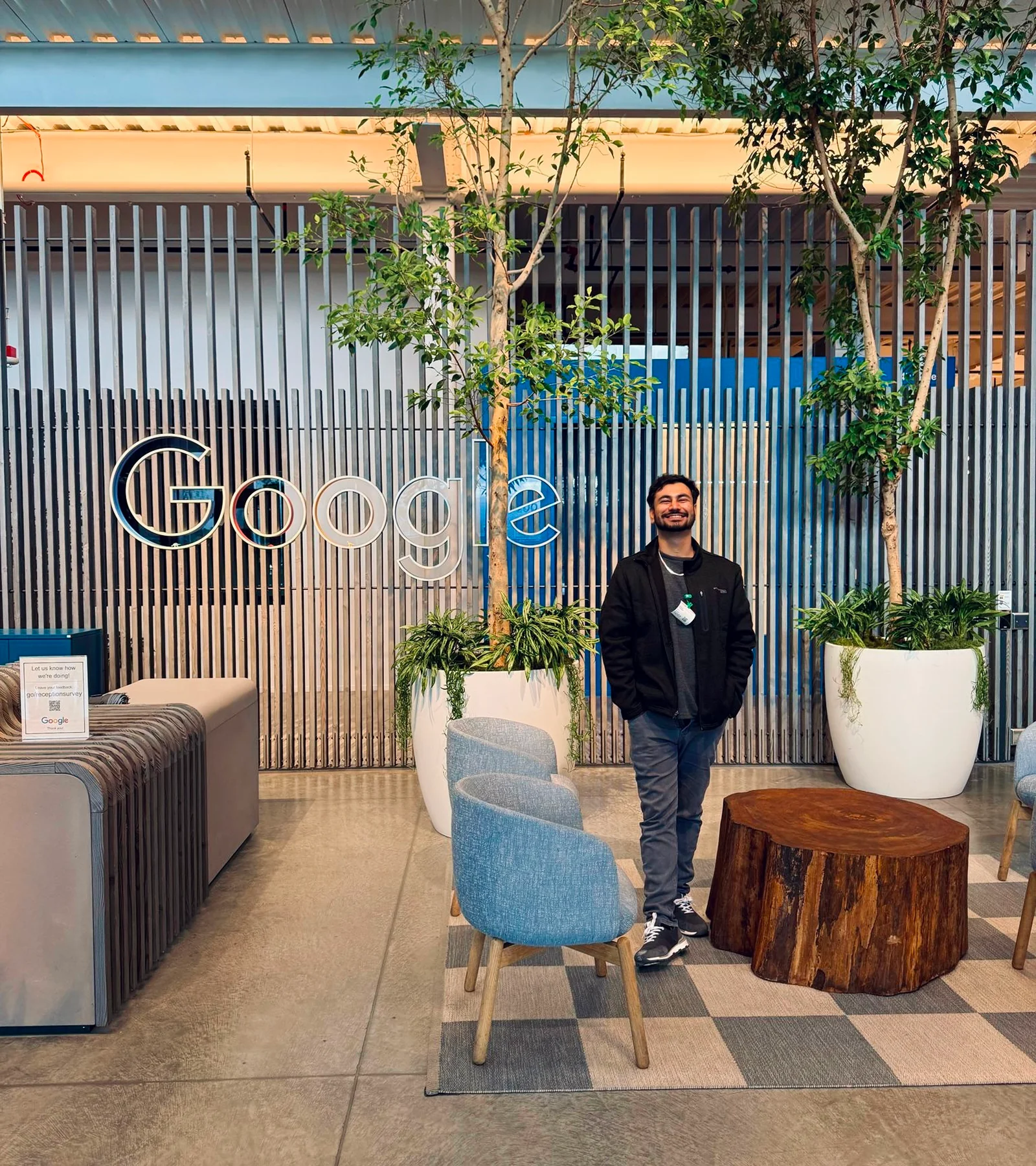 Waqar Hussain, Icon Pro Solutions CEO, standing in an office lobby beside a large Google sign