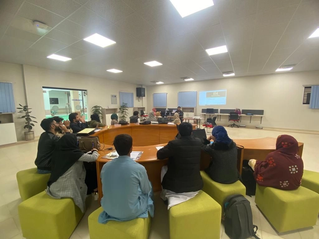 Interns and staff sitting around a large round table in a meeting hall